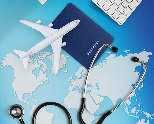 international medical travel insurance concept,stethoscope, passport, computer and airplane on sky background with global map